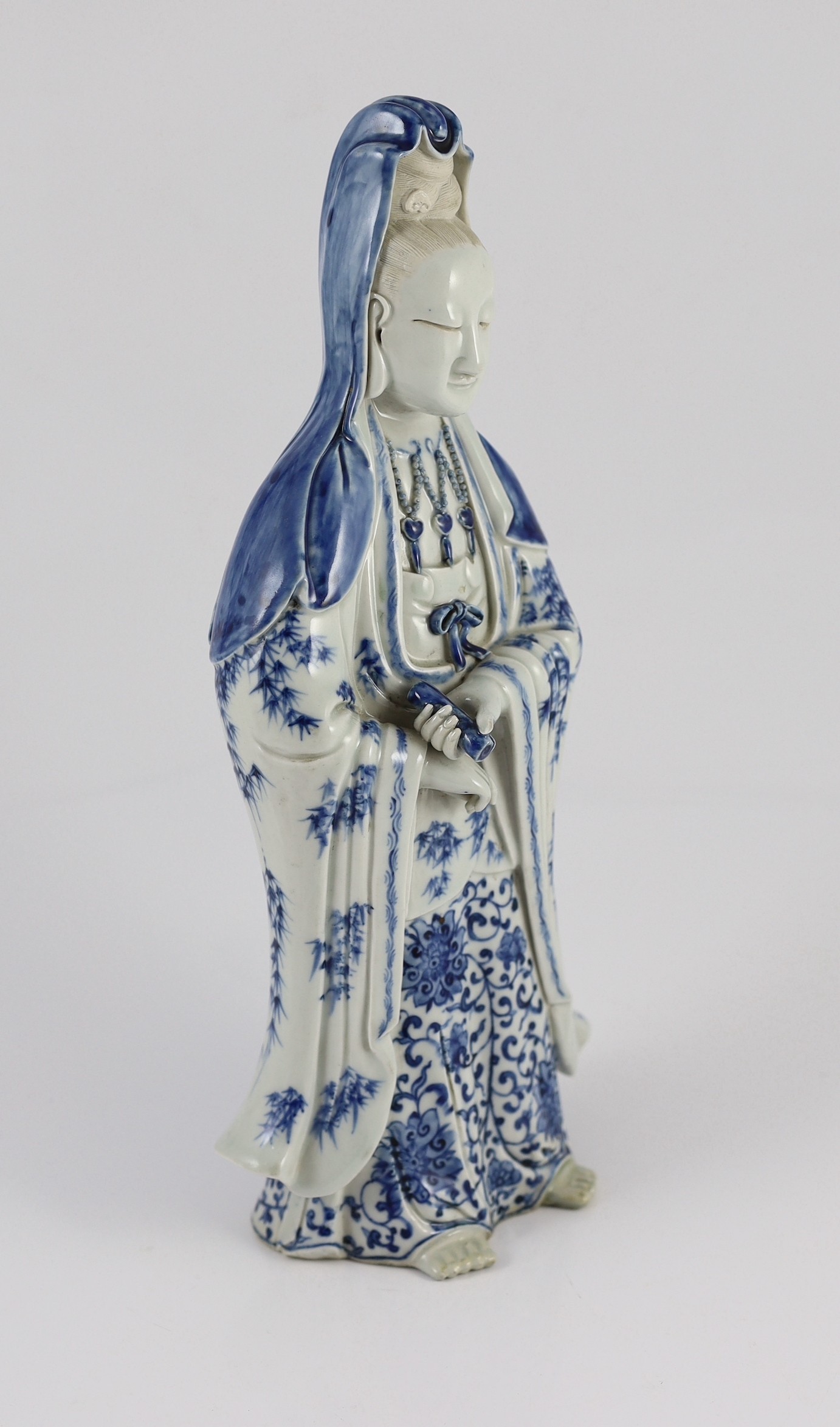 A Chinese blue and white standing figure of Guanyin, late 19th century, 34.5cm high, restoration to left foot